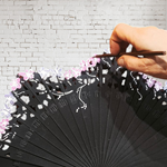 ABANICO baraja con calado,  color negro, dibujo de flor en tono rosa y malva, madera de arce lacado, tamaño medio