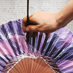 ABANICO  en seda y madera de peral, dibujo de flor de grandes pétalos malva. Talla clásico